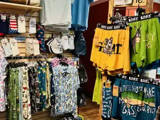 Clothing and bags display at Marshalls store with shirts, shorts, and accessories.
