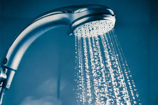 A sparkling clean showerhead sprays refreshing streams of water against a blue background. Trust Moore Home Services for expert plumbing solutions to keep your fixtures running smoothly—backed by our satisfaction guarantee and commitment to leaving your home as clean as we found it.