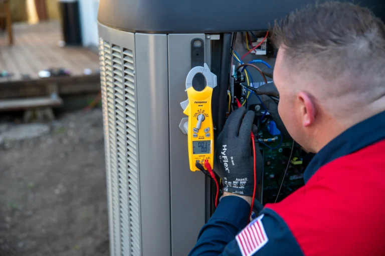A Moore Home Services technician, wearing protective gloves, uses a digital multimeter to expertly inspect the electrical components inside an outdoor HVAC unit. Our team is dedicated to delivering trustworthy heating and cooling service with our satisfaction guarantee and commitment to leaving your home as clean as we found it.