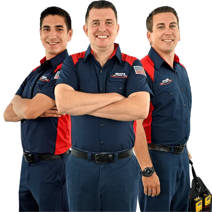 Three Moore Home Services team members, dressed in crisp navy blue and red uniforms with name tags, stand side by side with friendly smiles and arms crossed. Our trusted HVAC, plumbing, and drain professionals are dedicated to delivering clean, reliable service backed by industry-leading guarantees—ensuring your home's comfort is always in expert hands.