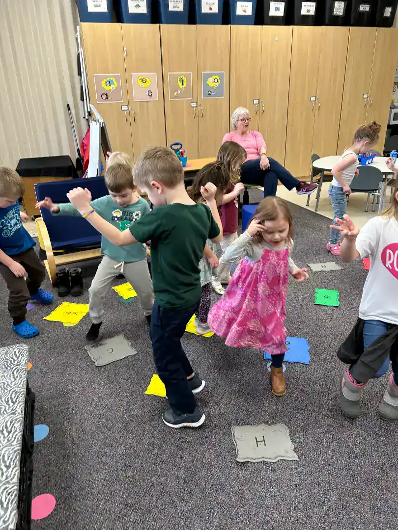 Children playing and dancing in classroom at New Era Christian School.