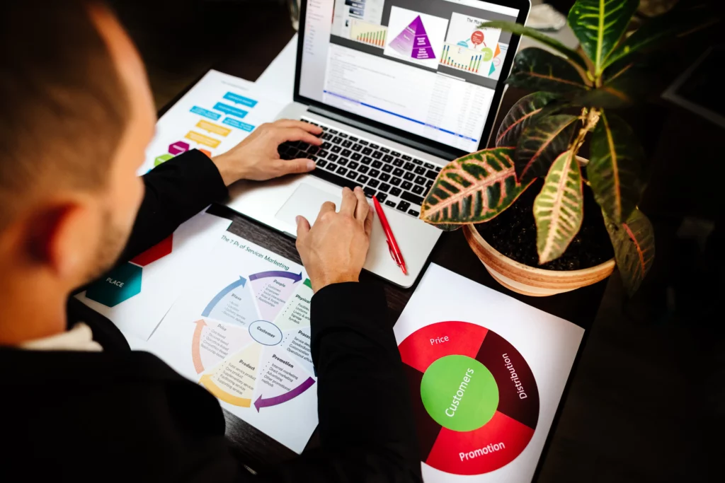 Digital Marketing Agency A person working at a desk with a laptop, business charts, diagrams, and a potted plant. Paradox Media