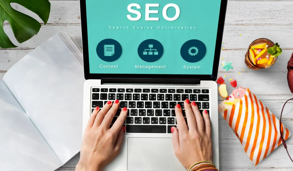 A local SEO specialist typing on a laptop displaying an SEO (Search Engine Optimization) screen with icons for Content, Management, and System Settings.