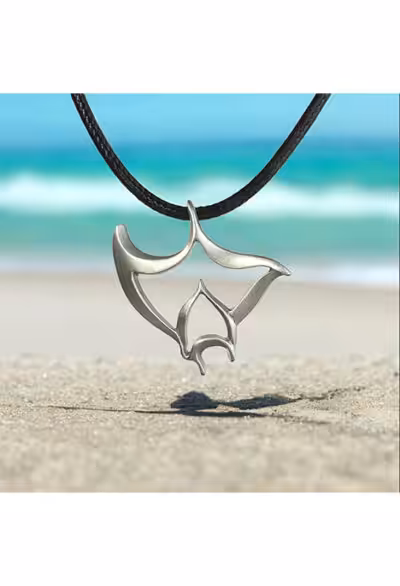 Un pendentif en forme de raie manta évoque l'élégance marine sur une plage ensoleillée, parfait pour les passionnés de plo...