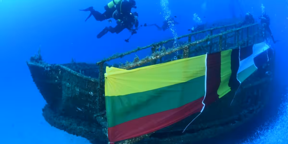 Plongée sous-marine près d'un épave décorée de drapeaux colorés. Exploration marine fascinante.