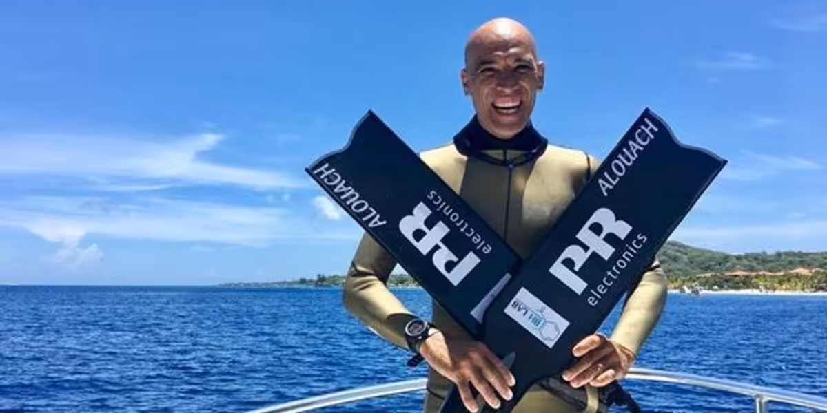Homme en combinaison de plongée avec palmes, prêt pour l'aventure sous-marine.