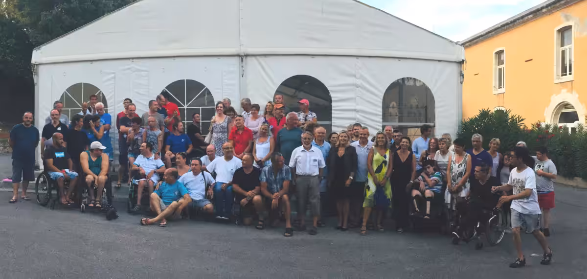 Groupe de personnes rassemblées autour d'un événement festif en plein air.