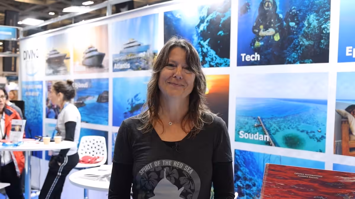 Femme souriante dans un salon de plongée sous-marine, ambiance maritime et exploration.