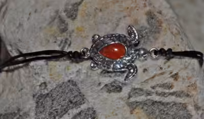 Bracelet en argent représentant une tortue marine, symbole de protection et de sagesse.