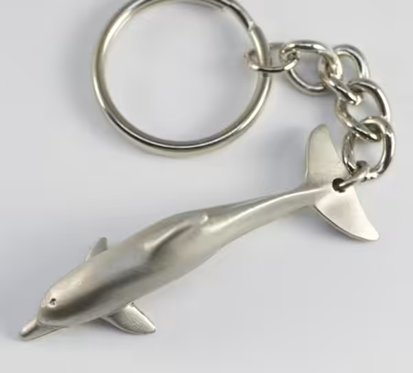 Un porte-clés en étain en forme de dauphin, idéal pour les passionnés de plongée et d'aventure marine.