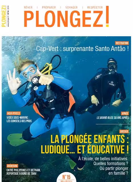 Deux plongeurs explorent les profondeurs marines, illustrant l'aventure éducative de la plongée pour enfants.