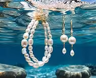 Des bijoux en perles flottent élégamment sous l'eau cristalline, évoquant la richesse mystérieuse des fonds marins.