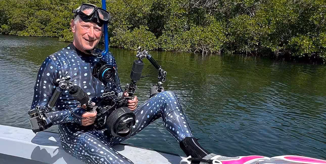 Un plongeur équipé d'une combinaison à motifs et d'un appareil photo sous-marin se prépare à explorer les mangroves. #Plongée