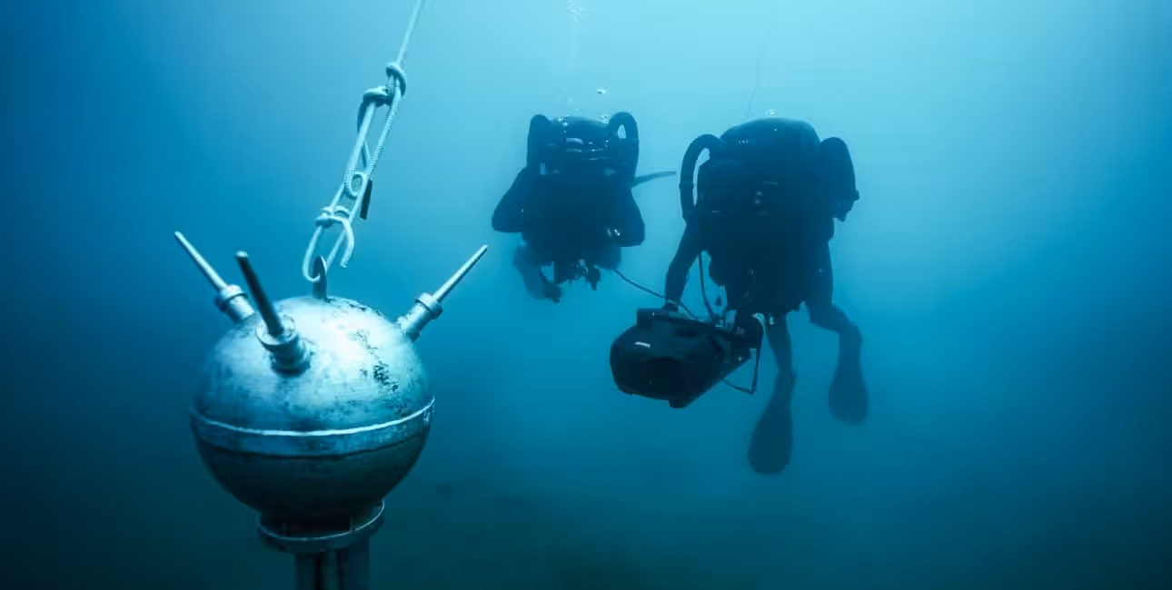 Deux plongeurs démineurs explorent les profondeurs marines, illustrant la sécurité sous-marine essentielle. 🐠
