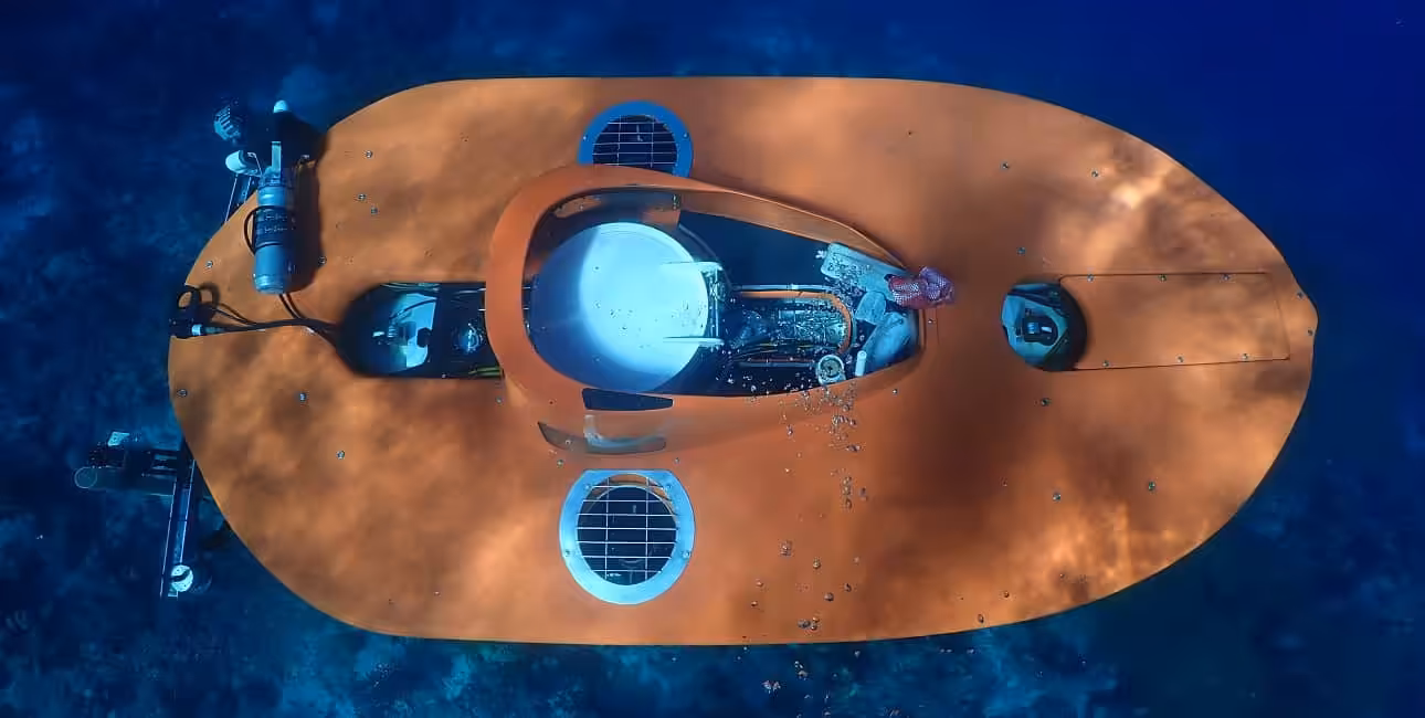 Un sous-marin orange explore les profondeurs cristallines de Curaçao, offrant une perspective unique sur la biodiversité m...