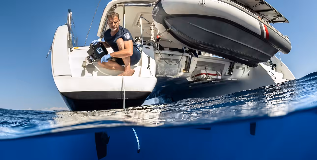 Un chercheur collecte des échantillons d'ADN environnemental depuis un bateau, illustrant l'importance de la conservation ...