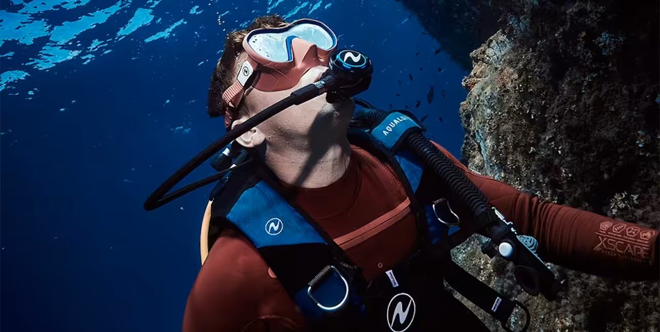 Un plongeur explore les profondeurs marines, entouré de poissons, illustrant l'aventure sous-marine.