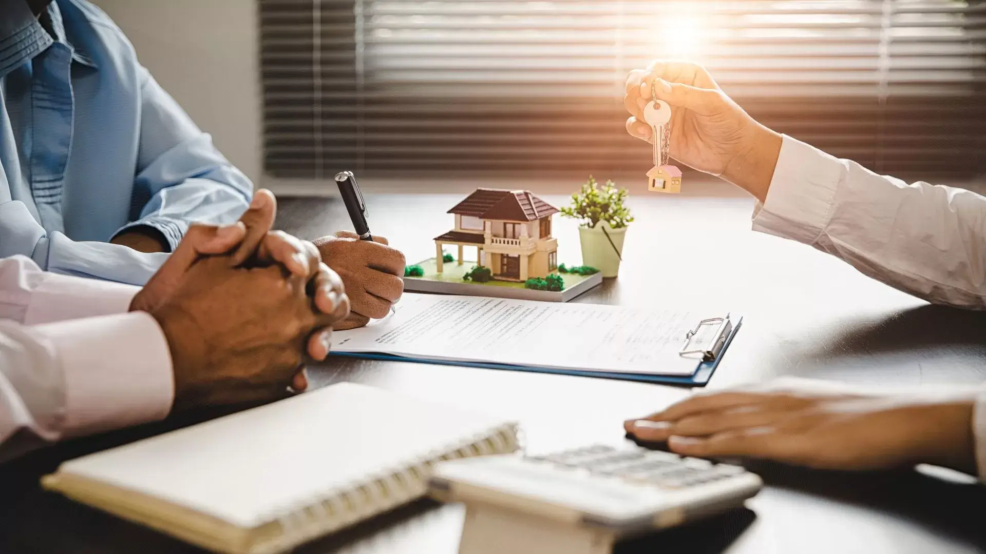 a person is sitting down at a desk with their homeowners insurance agency to adjust thier policy to ensure their screen enclosure is protected. 