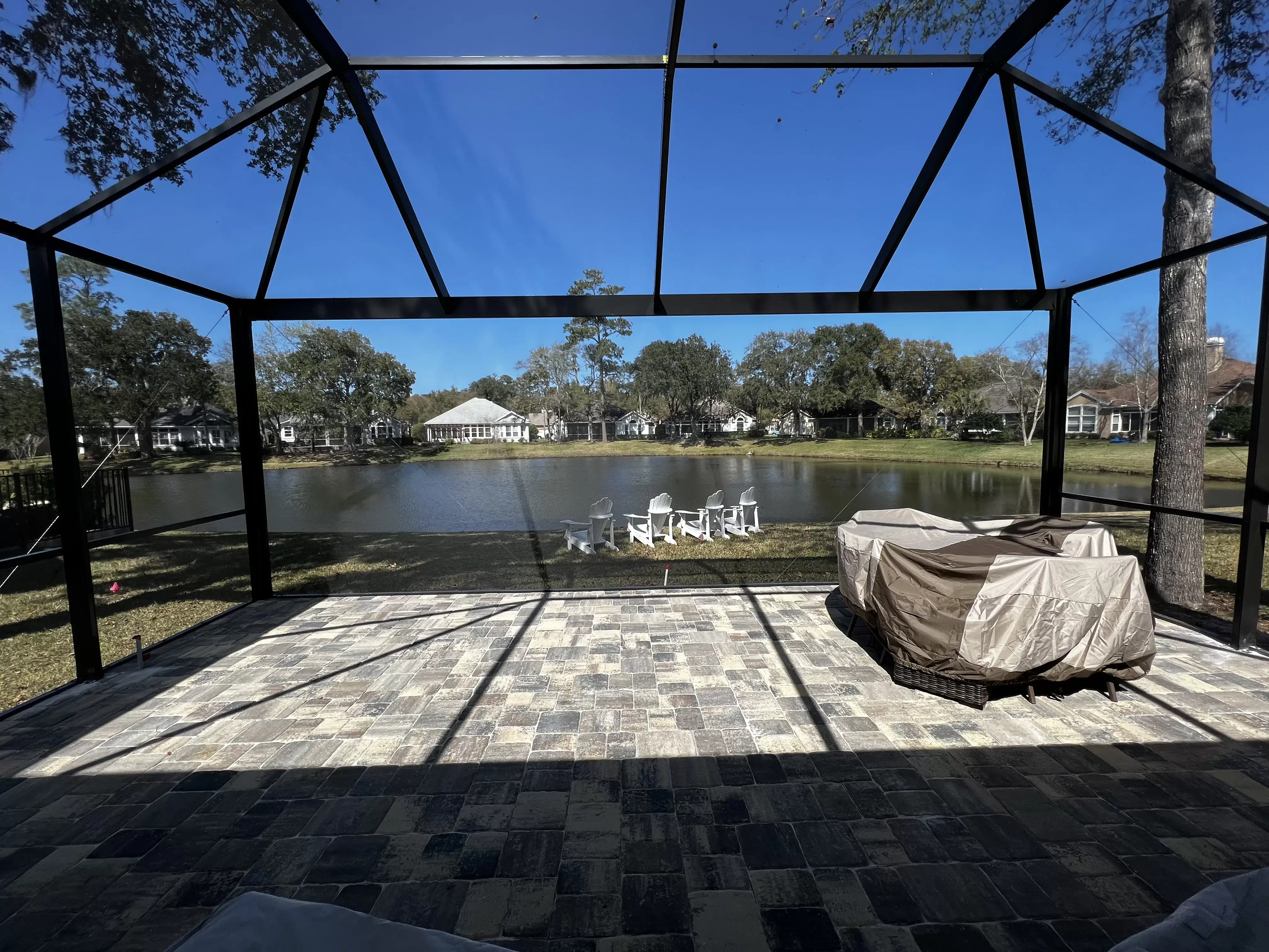 a beautiful lanai extension with a paver patio overlooking the lake.