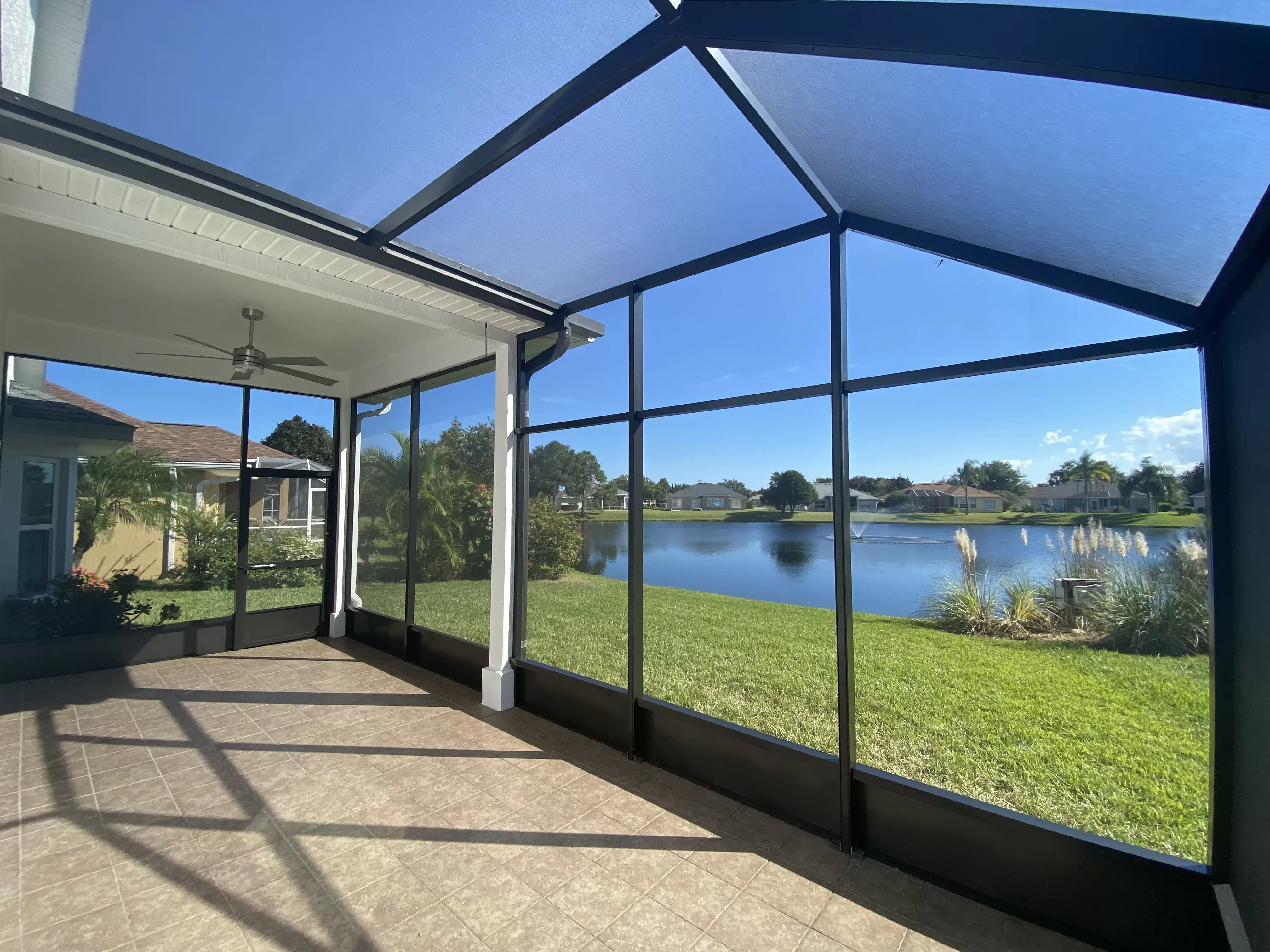 A beautiful lanai enclosure overlooks a lake. 