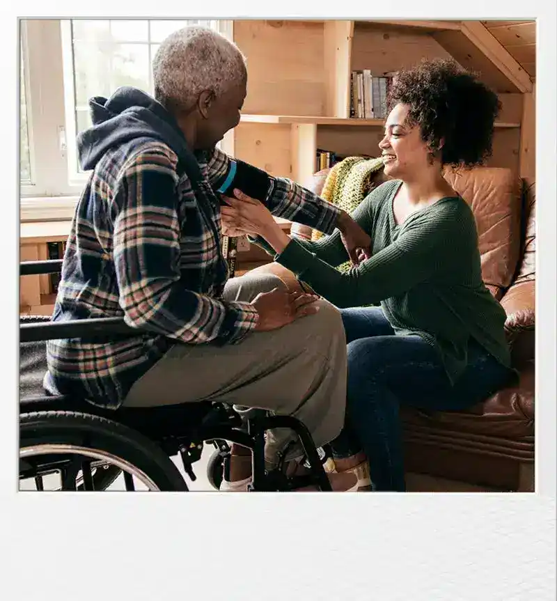 Nurse measuring blood pressure of elderly woman in a cozy home setting.