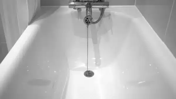A spotless white bathtub with a secure drain chain and reliable faucet, ready for expert care from your trusted local team.