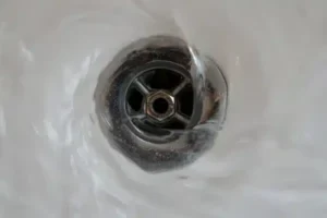 Water gently swirls down a metal drain, demonstrating smooth, reliable flow—just like Service Champions’ expert care for your home.