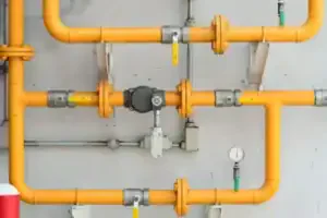 Yellow gas pipes with valves and a pressure gauge, showcasing reliable Service Champions expertise for safe, comfortable SoCal homes.