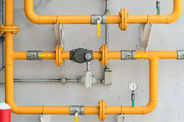 Yellow gas pipes with valves and a pressure gauge, showcasing reliable Service Champions expertise for safe, comfortable SoCal homes.