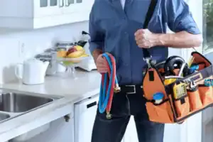 A friendly Service Champions plumber in Brea, CA stands ready by the sink, equipped to provide reliable, customer-focused help.