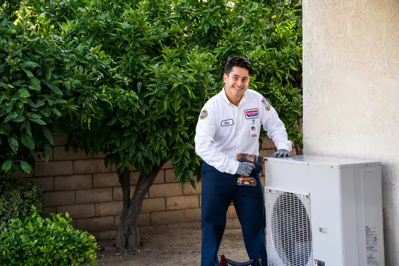 A friendly Service Champions technician installs a heat pump on an AC unit outside a Brea, CA home, ensuring dependable comfort.