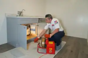A friendly plumber expertly clears a drain in a Brea, CA kitchen, showing Service Champions’ trusted, customer-focused care.