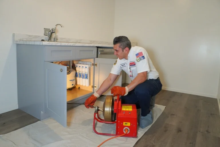 A friendly plumber expertly clears a drain in a Brea, CA kitchen, showing Service Champions’ trusted, customer-focused care.