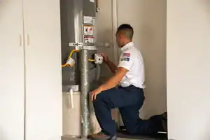 A caring Service Champions technician checks a home water heater in Brea, CA, delivering trusted comfort and plumbing expertise.
