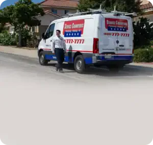 A friendly Service Champions technician stands by a company van on a sunny neighborhood street, ready to serve local families’ comfort needs.