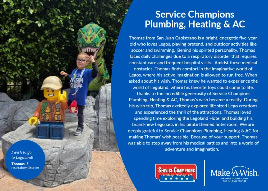 A joyful boy stands before a Lego display at Legoland, sword in hand, with Make-A-Wish and Service Champions banners nearby.