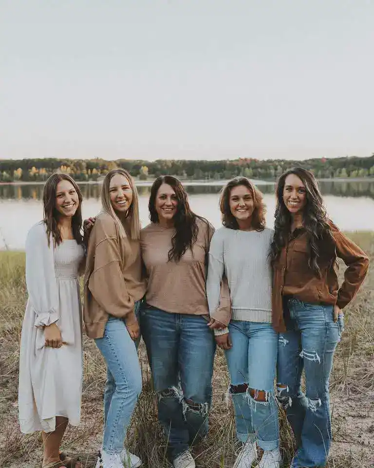 Group of women holding hands outdoors near a lake, smiling, for Custom Cookies post.