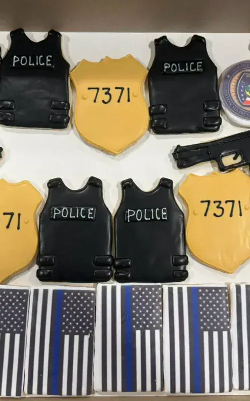 Police-themed cookies with guns badges and flags for custom orders.