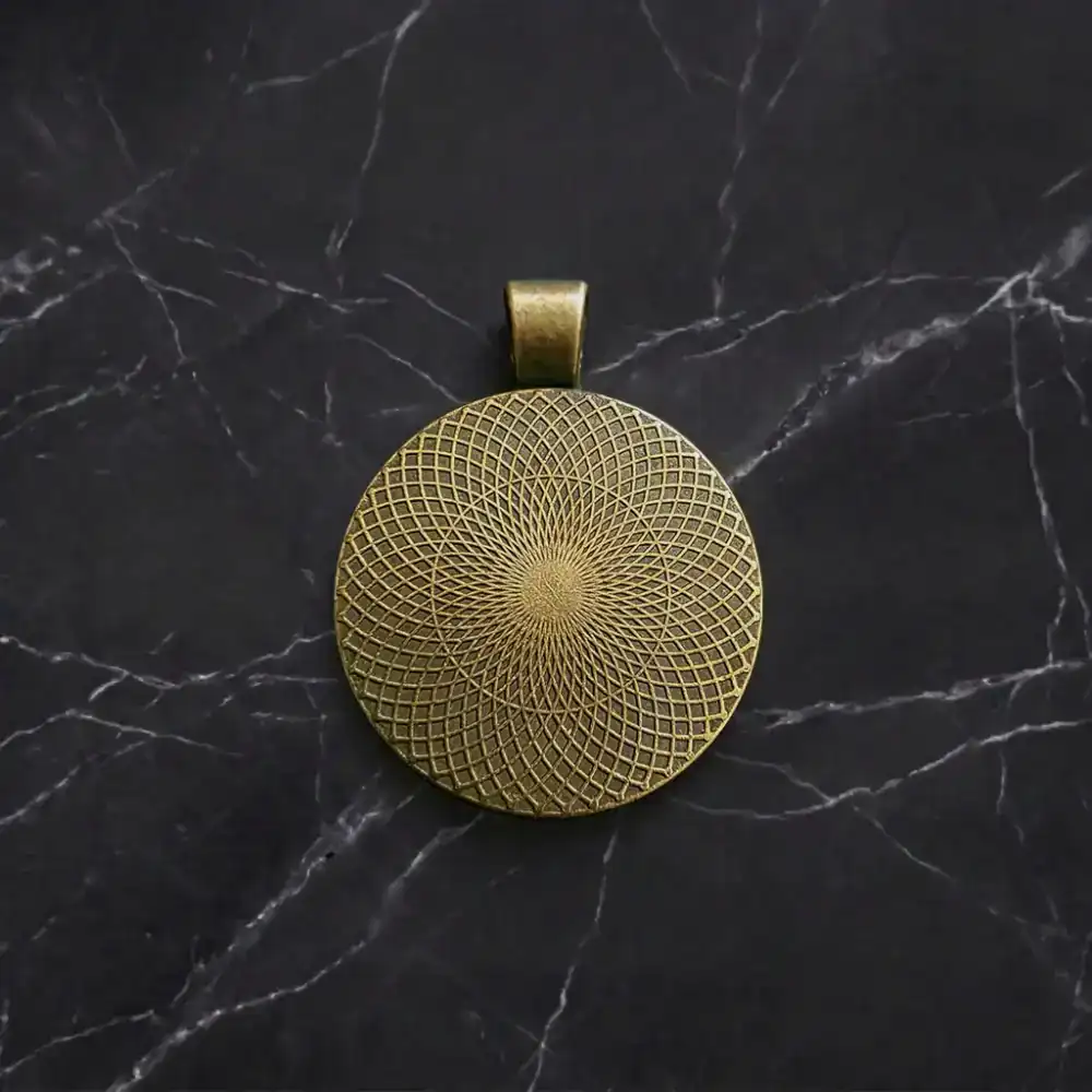 Antique Bronze Backside Pattern - Jesus Christ Pendant Textured geometric lattice pattern on the back of a vintage antique bronze round pendant setting on dark marble.
