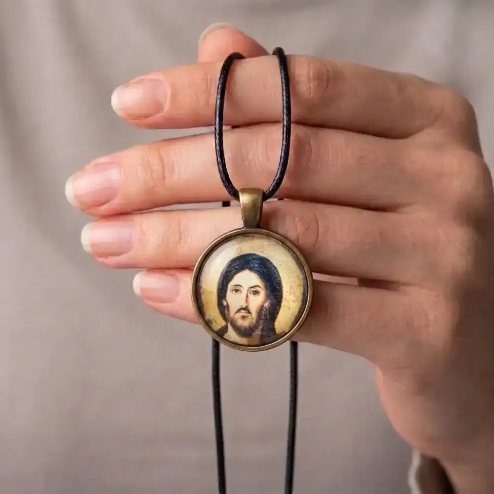 Jesus Christ Pantocrator Pendant Hand-Held Wearer Perspective Person holding a round Jesus Christ Pantocrator glass cabochon necklace over their hand to show wearable scale.