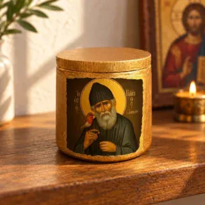 Saint Paisios Ceramic Keepsake Jar with Lid sitting on a wooden home prayer altar next to a candle and Christ icon