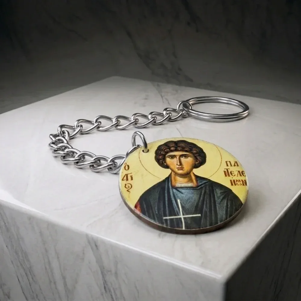 Saint Panteleimon Wood Mounted Keychain - Display Block View Saint Panteleimon wood mounted keychain lying flat on a white marble display block showing chain and key ring