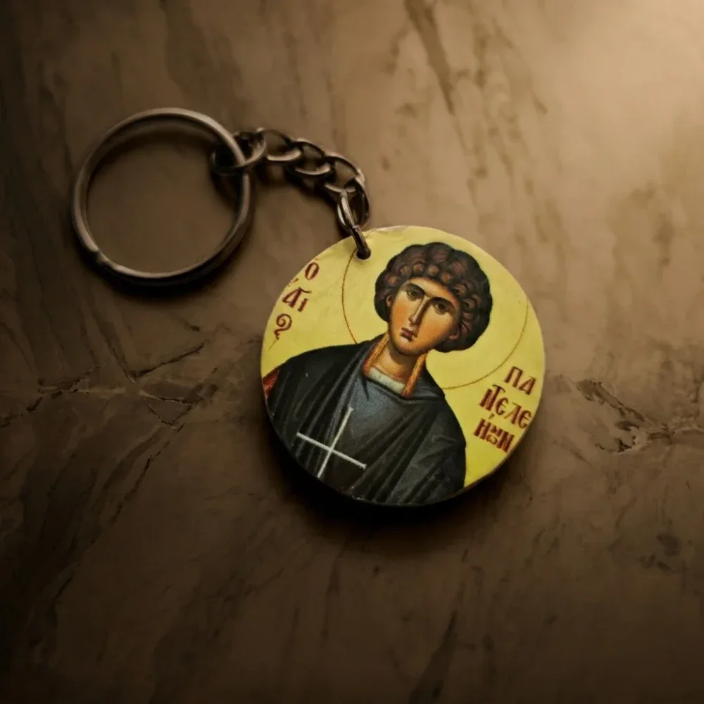 Saint Panteleimon Wood Mounted Keychain - Icon Detail View Close-up view of Saint Panteleimon wood mounted keychain showing the sealed and waxed Orthodox icon disc on warm marble
