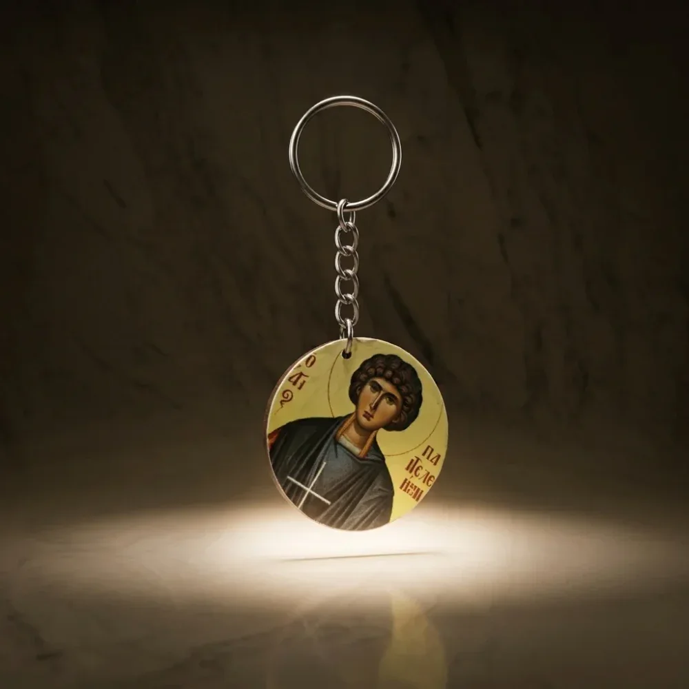 Saint Panteleimon Wood Mounted Keychain - Spotlight View Floating handcrafted Saint Panteleimon wood mounted keychain with metallic chain and split key ring under spotlight