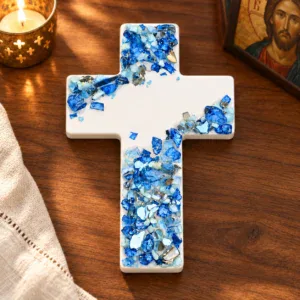 White ceramic wall cross with blue and pale blue mosaic accents in a warm prayer corner