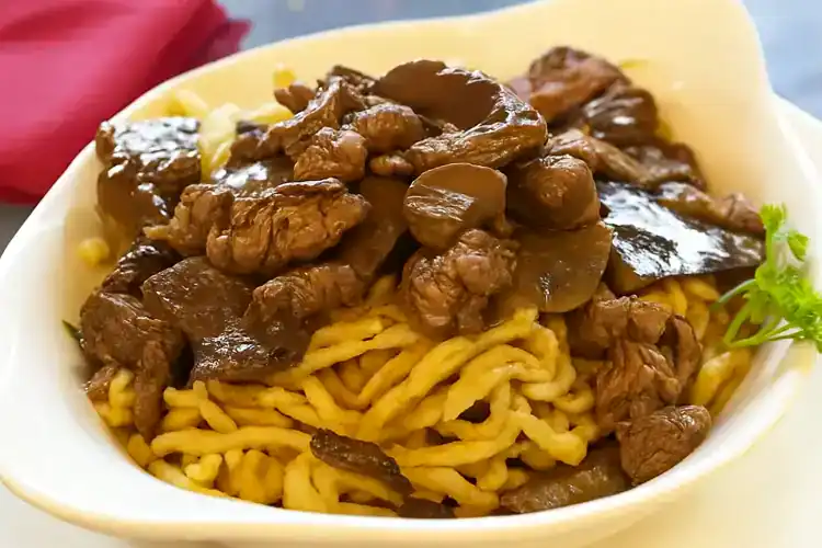 Beef spaetzle served with savory gravy and tender meat pieces.