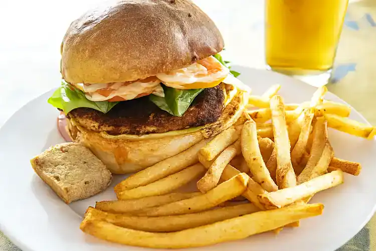 Delicious blackened chicken sandwich with fresh lettuce and crispy fries.