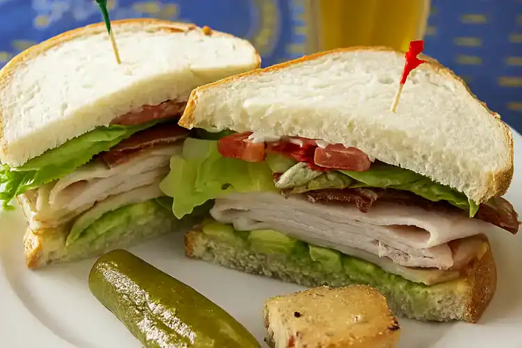 Delicious California Club Sandwich with fresh lettuce and turkey.