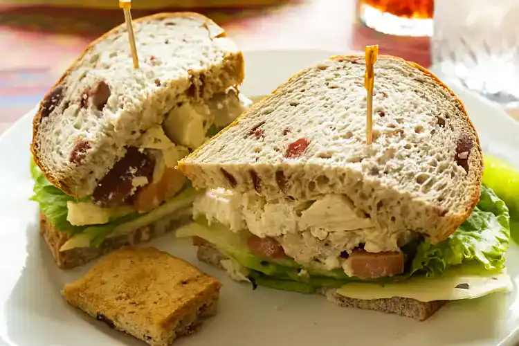 Fresh chicken salad sandwich on multigrain bread with lettuce and tomato.