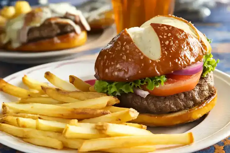 Juicy beef burger with lettuce, tomato, onion, and cheese served with fries.